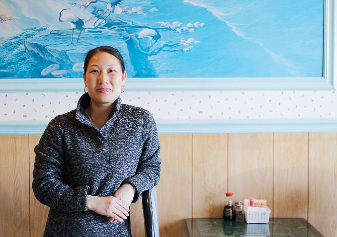 Amy Luo was 19 when she moved to the U.S. from Fuzhou, China. Here, she stands in a Holts Summit restaurant where she works.