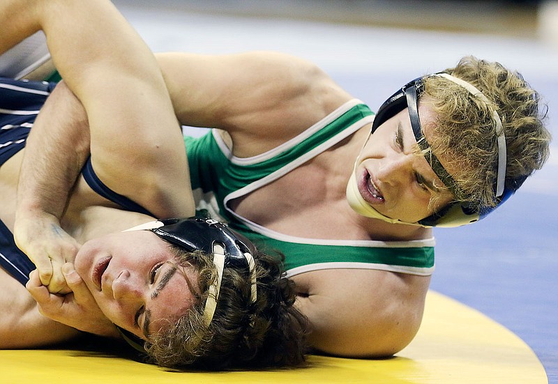 Devan Lewis of Smithville (right) wraps his arms around the shoulders of Helias' Aleksey Salaz during their 138-pound title match Saturday at the Class 3 state wrestling championships at Mizzou Arena.