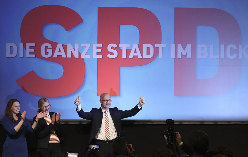 Social Democratic Party, SPD, top candidate and First Mayor of Hamburg Peter Tschentscher, right, celebrates with supporters after exit polls for the Hamburg state elections announced in Hamburg, Germany, Sunday, Feb. 23, 2020. Hamburg, Germany's second-biggest city which is also one of Germany's 16 federal states, elect a new regional assembly. Left are SAD member Melanie Leonhardlevt, and Peter Tschentscher wife Eva-Maria Peter Tschentscher, second from left. (Christian Charisius/dpa via AP)
