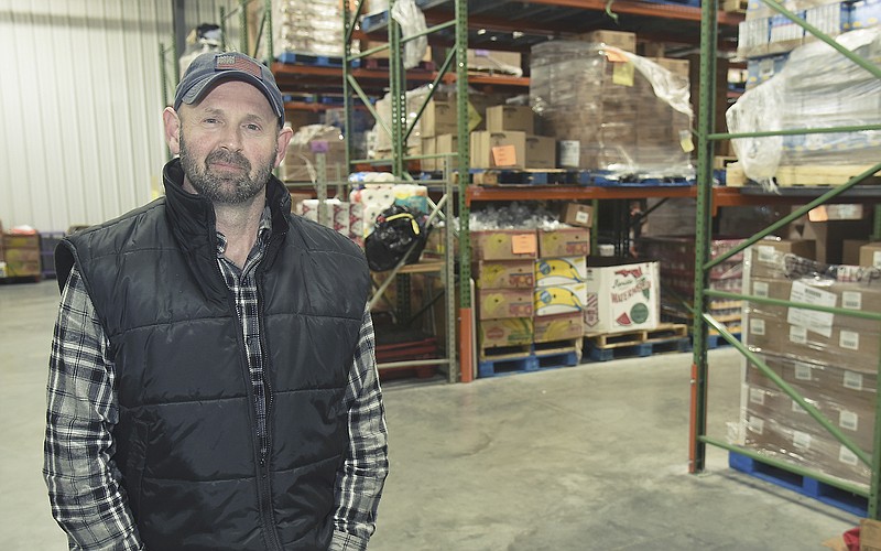 Shane Boessen poses in the new warehouse space at Samaritan Center where he serves as warehouse manager for the pantry.