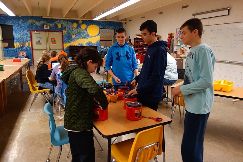 <p>Democrat photo/Paula Tredway</p><p>Tristian Nikes, Richard Burger, Ayden Howard and Ty McDonald prepare containers for the penny war against grades. The winning grade gets to pick a teacher to kiss a pig.</p>