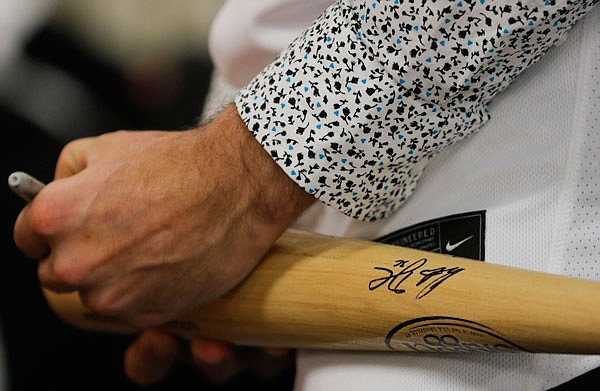 Dylan Carlson signs a bat before the Cardinals Caravan event in January at Missouri Farm Bureau.