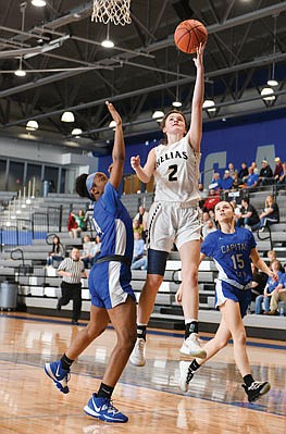 Corde Brown of Capital City shoots the ball against the defense of Camdenton's Patrick Glynn during Saturday afternoon's Class 4 District 10 Tournament game at Capital City.