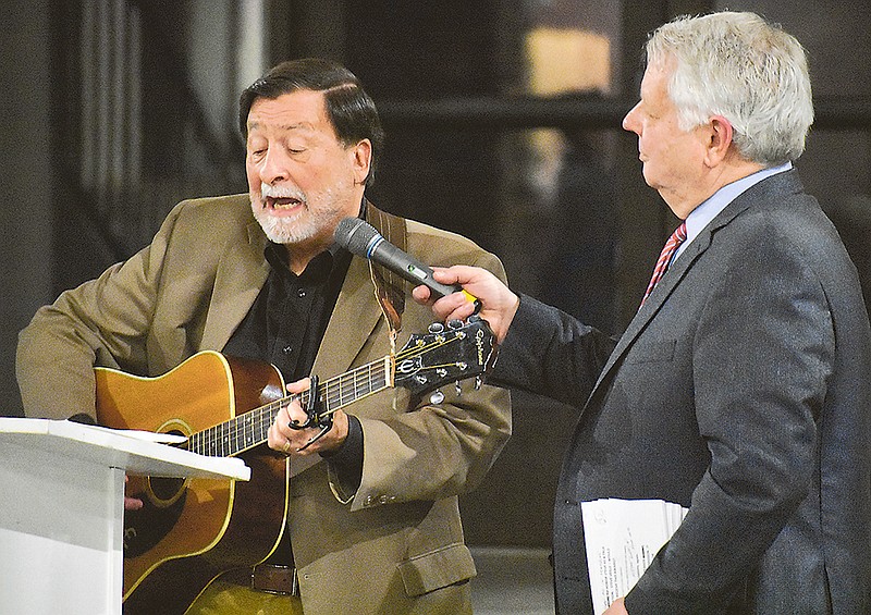 KRCG TV 13's Dick Preston holds the mic for Steve Veile as he plays a song about Jefferson City during Sunday's Historic City of Jefferson Membership Celebration Dinner at Capital Bluffs Event Center.