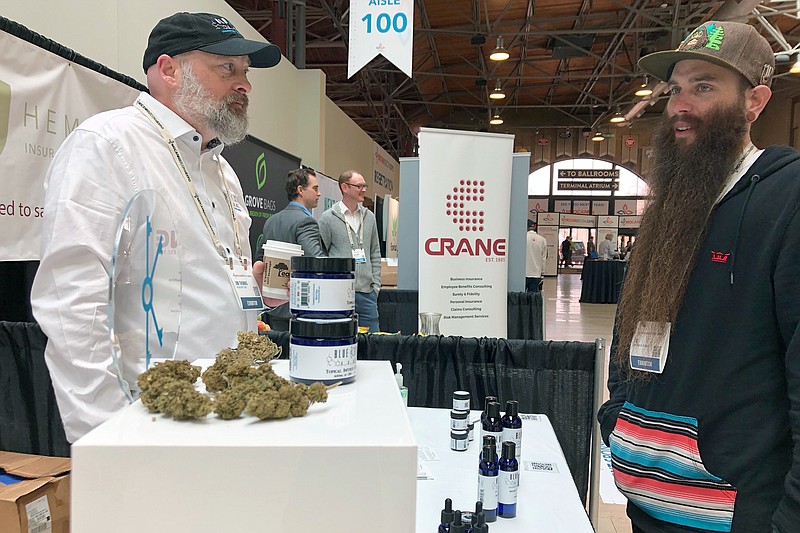 T.K. Killian, right, speaks with Blue Key operator Jim Thomas at a marijuana business conference in St. Louis on Tuesday, March 2, 2020. (AP Photo by Jim Salter)