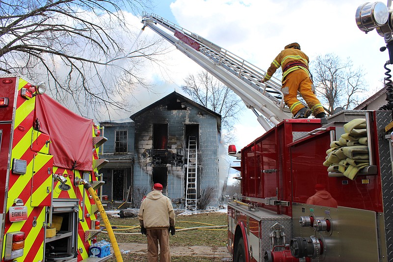 Democrat photo/Austin HornbostelFirst responders work to put out a house fire on East South Street Friday afternoon.