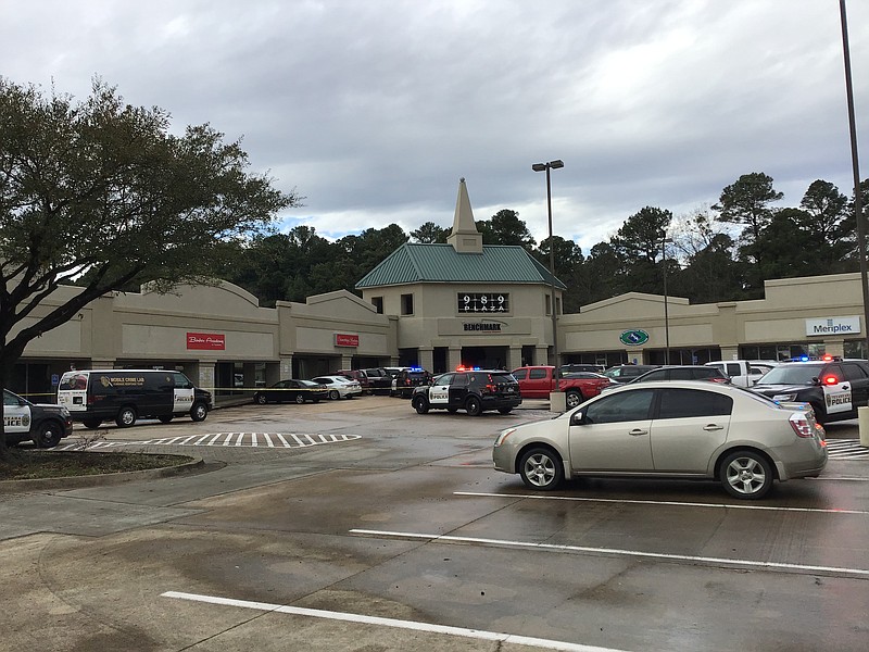 Police cars and crime-scene tape block the public from the Cosmetology Academy in Texarkana, Texas, where a man shot his estranged wife in the leg before allegedly killing himself in parking lot.