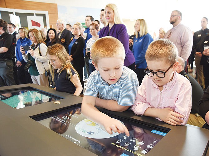 Brothers Tucker Hurst, right, 8, and Landry, 7, play Thursday on the Activity Table at the Center for Soy Innovation during an open house. The event featured tours and a ribbon-cutting ceremony for the center at 734 Country Club Drive. The brothers and their sister, Elliott, 3, live on a farm in Tarkio and are the children of Missouri Soybean Association Board member Brooks Hurst. The family was in Jefferson City for the event, which drew a large crowd for the ceremonies. At left on the table is Ella Wheeler, daughter of Gary Wheeler, CEO of the association. 