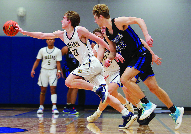 Colby LeCuru of Helias swats the ball out of Boonville's possession during last Thursday night's Class 4 District 10 Tournament title game at Capital City High School.