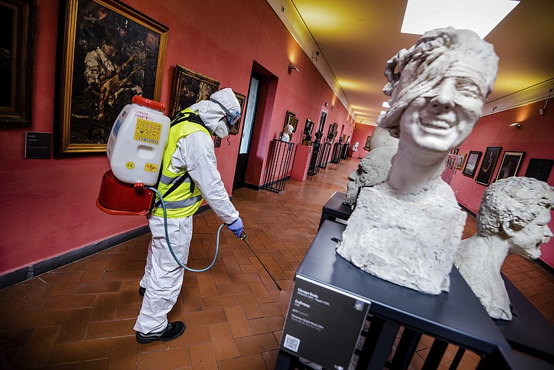 A worker sprays disinfectant as sanitization operations against Coronavirus are carried out in the museum hosted by the Maschio Angioino medieval castle, in Naples, Italy, Tuesday, March 10, 2020. (Alessandro Pone/LaPresse via AP)