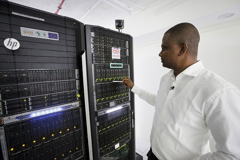 In this photo taken on Thursday, March 5, 2020, Abubakr Salih Babiker, a climate scientist at the Intergovernmental Authority on Development's Climate Prediction and Applications Center, shows server racks containing a supercomputer in Nairobi, Kenya. A supercomputer is boosting efforts in East Africa to control a locust outbreak that raises what the U.N. food agency calls "an unprecedented threat" to the region's food security. (AP Photo/Khalil Senosi)