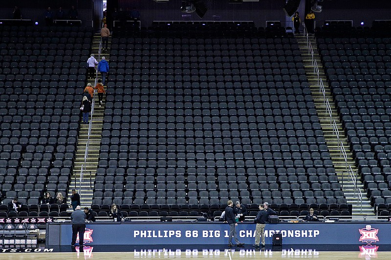 Fans leave the Sprint Center after the remaining NCAA college basketball games after in the Big 12 Conference tournament were canceled due to concerns about the coronavirus Thursday, March 12, 2020, in Kansas City, Mo. (AP Photo/Charlie Riedel)