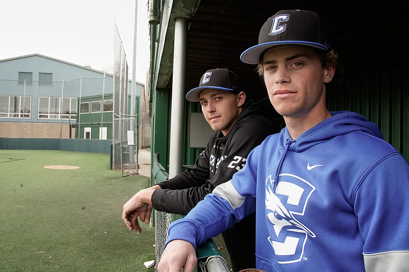 In this March 13, 2020 photo, Creighton NCAA college baseball pitchers Ben Dotzler and Tommy Steier, right, stand in the third base dugout in Omaha, Neb. Dotzler was supposed to be in the bullpen at TD Ameritrade Park this weekend readying himself to pitch against Northern Colorado. College athletes who play spring sports have a lot of free time this weekend after conferences announced they were suspending or canceling competitions because of concern about the spread of the new coronavirus. That happened after the NCAA announced Thursday it was canceling all spring sports championships, along with remaining winter championships.  (AP Photo/Nati Harnik)