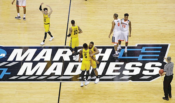 In this March 16, 2018, file photo, UMBC players celebrate their 74-54 win against Virginia in an NCAA Tournament first-round game in Charlotte, N.C. UMBC was the first No. 16 seed to ever beat a No. 1 seed in the men's NCAA Tournament. 