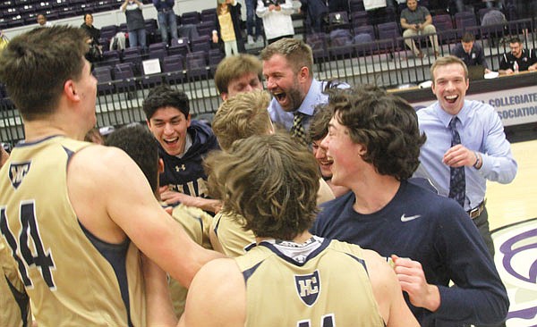 Helias coach Joe Rothweiler (center) celebrates with his team on the court after the Crusaders defeated Webb City 63-54 in the Class 4 quarterfinals Saturday at Southwest Baptist in Bolivar.