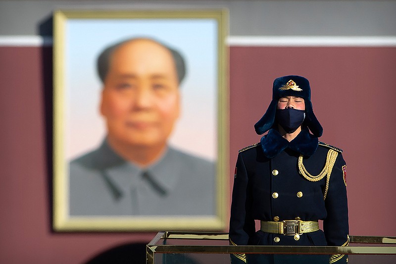  In this Tuesday, Feb. 4, 2020 file photo, a member of an honor guard wears a face mask as he stands guard in Tiananmen Square in Beijing. On Wednesday, March 17, 2020, China announced that it will revoke the media credentials of American journalists at three major U.S. news organizations, in effect expelling them from the country, in response to new U.S. restrictions on Chinese state-controlled media. (AP Photo/Mark Schiefelbein)