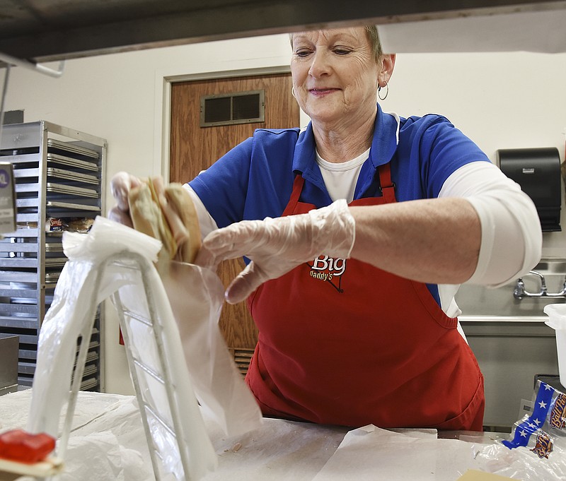 Pat Davenport, a cook at Thorpe Gordon Elementary School, prepares sandwiches that will be handed to parents picking them up for students March 18, 2020.