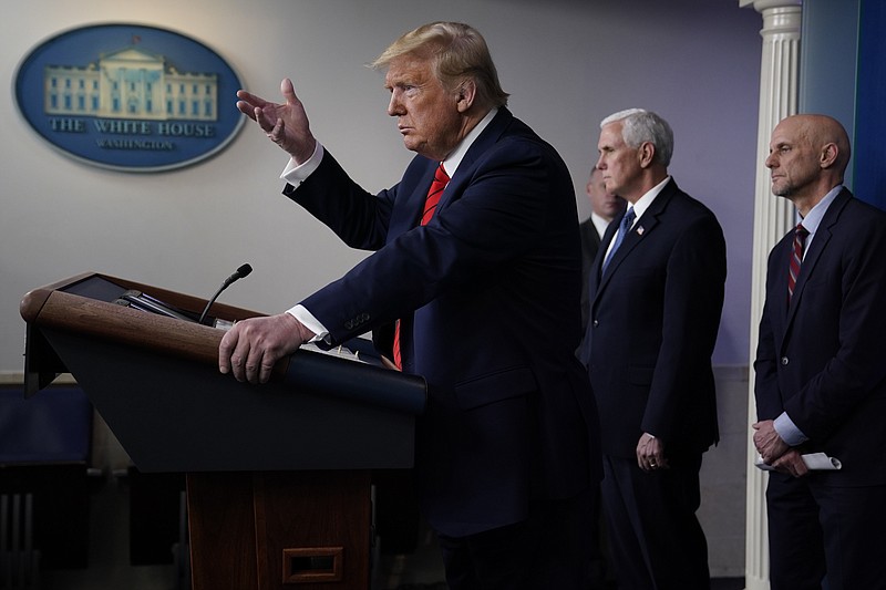 President Donald Trump speaks during press briefing with the coronavirus task force, at the White House, Thursday, March 19, 2020, in Washington. Food and Drug Administration Commissioner Dr. Stephen Hahn, right, and Vice President Mike Pence listen. (AP Photo/Evan Vucci)
