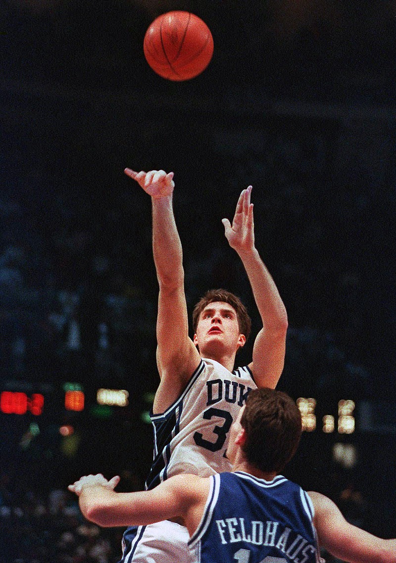 In this March 28, 1992, file photo, Duke's Christian Laettner takes the winning shot in overtime over Kentucky's Deron Feldhaus for a 104-103 victory in the East Regional final NCAA college basketball game in Philadelphia. (AP Photo/Charles Arbogast, File)