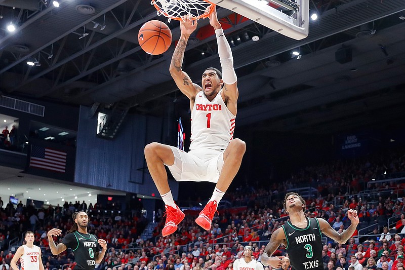 In this Dec. 17, 2019, file photo, Dayton's Obi Toppin (1) dunks as North Texas' Javion Hamlet (3) looks on during the second half of an NCAA college basketball game in Dayton, Ohio. Toppin is the lone unanimous first-team choice to The Associated Press men's college basketball All-America team, Friday, March 20, 2020. (AP Photo/John Minchillo, File)