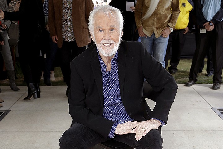 FILE - In this Oct. 24, 2017 file photo, Kenny Rogers poses with his star on the Music City Walk of Fame in Nashville, Tenn. Actor-singer Kenny Rogers, the smooth, Grammy-winning balladeer who spanned jazz, folk, country and pop with such hits as "Lucille," "Lady" and "Islands in the Stream" and embraced his persona as "The Gambler" on record and on TV died Friday night, March 20, 2020. He was 81. (AP Photo/Mark Humphrey, File)