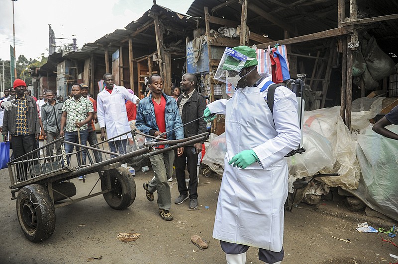A Kenyan Health Ministry official sprays disinfectant onto a hand-cart to control the spread of the new coronavirus, in the Gikomba outdoor street market in the capital Nairobi, Kenya Saturday, March 21, 2020. For most people, the new coronavirus causes only mild or moderate symptoms such as fever and cough and the vast majority recover in 2-6 weeks but for some, especially older adults and people with existing health issues, the virus that causes COVID-19 can result in more severe illness, including pneumonia. (AP Photo/John Muchucha)