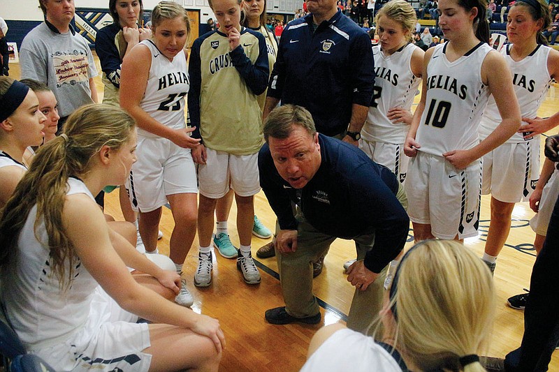 Helias coach Alan Lepper talks to his players before the start of the fourth quarter of a game against Jefferson City during the 2016-17 season at Rackers Fieldhouse.