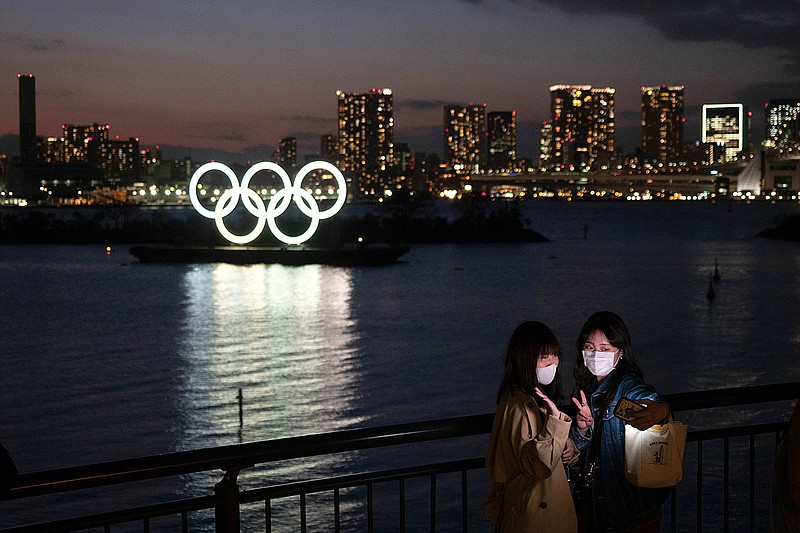 Two women take a selfie with the Olympic rings in the background on March 12 in Tokyo.  