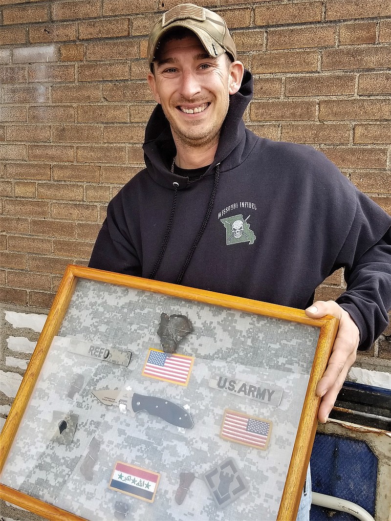 Matthew Reed, of St. Louis, holds a shadow box he made memorializing his service in Iraq with the U.S. Army. He now serves as a power generator mechanic with the Missouri National Guard.