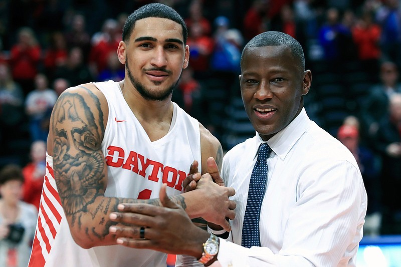 In this Feb. 22, 2020, file photo, Dayton's Obi Toppin, left, celebrates scoring his 1,000th career point with head coach Anthony Grant after an NCAA college basketball game against Duquesne, in Dayton, Ohio. Toppin and Grant have claimed top honors from The Associated Press after leading the Flyers to a No. 3 final ranking. Toppin was voted the AP men's college basketball player of the year, Tuesday, March 24, 2020. Grant is the AP coach of the year. (AP Photo/Aaron Doster, File)