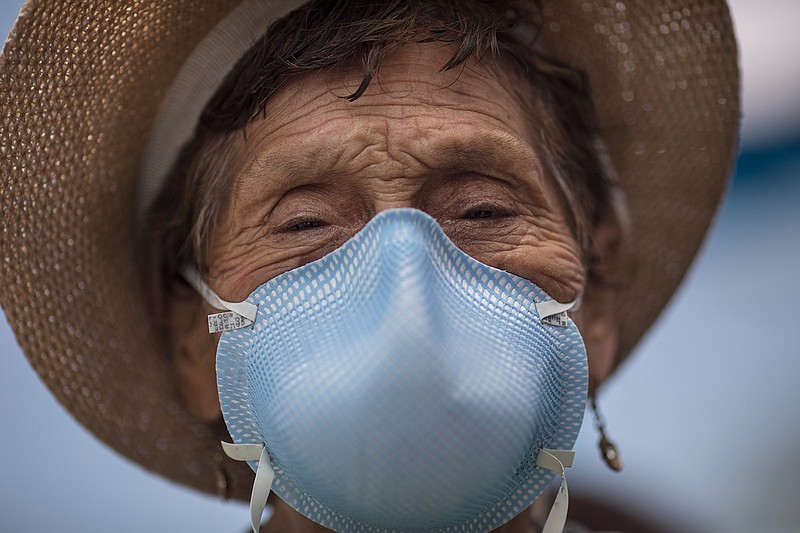 Ubaldina Calderon, 92, wearing a protective mask, exits a clinic after receiving a pneumonia vaccine as part of a mass vaccination campaign for older adults organized by the government, in Lima, Peru, Friday, March 13, 2020. The Ministry of Health is encouraging seniors to get a pneumonia vaccine to reduce the risks of those who might contact the new coronavirus. The vast majority of people recover from the new virus. (AP Photo/Rodrigo Abd)