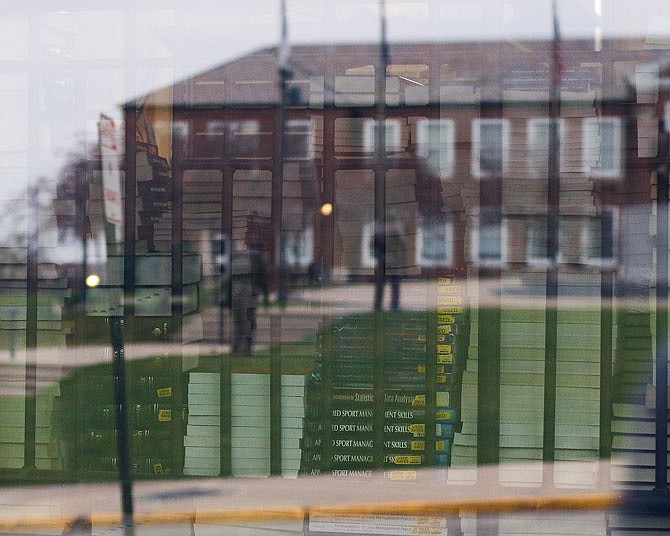 Lincoln University's recruitment office is reflected in the window of the Scruggs University Center, where hundreds of textbooks sit in stacks.