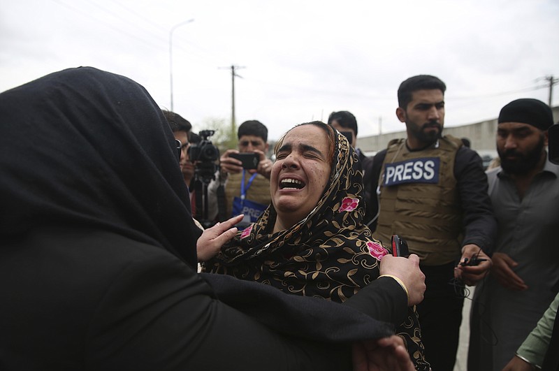 Family members cry after an attack in Kabul, Afghanistan, Wednesday, March 25, 2020. Gunmen stormed a religious gathering of Afghanistan's minority Sikhs in their place of worship in the heart of the Afghan capital's old city on Wednesday, a minority Sikh parliamentarian said. (AP Photo/Rahmat Gul)