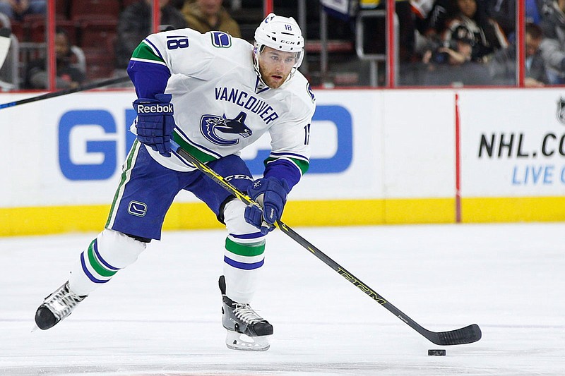 In this Jan. 12, 2015, file photo, Vancouver Canucks defenseman Ryan Stanton is shown during the first period of game against the Philadelphia Flyers in Philadelphia. Stanton, now playing for the American Hockey League Ontario Reign, drove 27 hours with his wife, 18-month-old daughter, mother-in-law and dog from Southern California to St. Albert, Alberta. The trip was prompted after the coronavirus pandemic put the American Hockey League Ontario Reign defenseman's season on hold last week. 