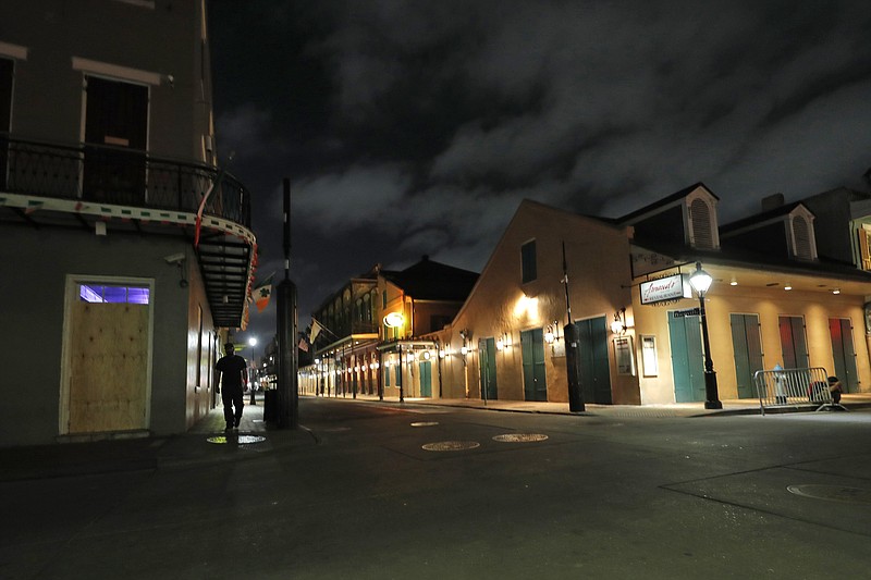 The nearly deserted Bourbon Street, which is normally bustling with tourists and revelers, stands in the French Quarter of New Orleans, Thursday, March 19, 2020. Louisiana Gov. John Bel Edwards and New Orleans Mayor Latoya Cantrell have ordered all restaurants and bars to close except for takeout, and asked residents to remain home and maintain social distancing from others when outside, due to the COVID-19 virus pandemic. (AP Photo/Gerald Herbert)