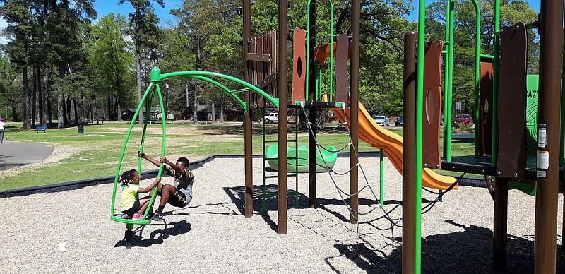 Children enjoy the playground Wednesday afternoon at Spring Lake Park. Texarkana, Texas, city officials have ordered the playgrounds in city parks closed until further notice. However, parks can still be visited.  