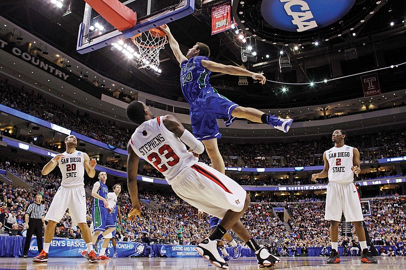 In this March 24, 2013, file photo, Florida Gulf Coast's Chase Fieler dunks over San Diego State's Deshawn Stephens during a Round of 32 game of the NCAA Tournament in Philadelphia. The Dunk City Effect, as it's called, accounted for a 35 percent increase in freshman applications following the team's run to the Sweet 16.