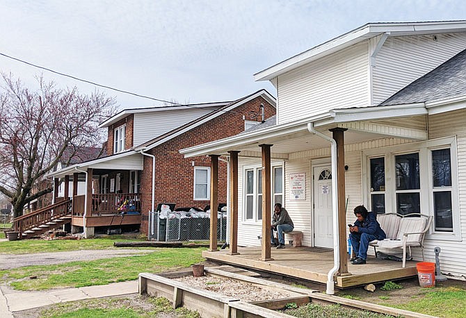 Jovonta Batte, left, and David Anderson take a break on the front porch of Wiley House. The shelter is remaining open 24/7 to keep its residents safe from COVID-19, Executive Director Misty Dothage said.