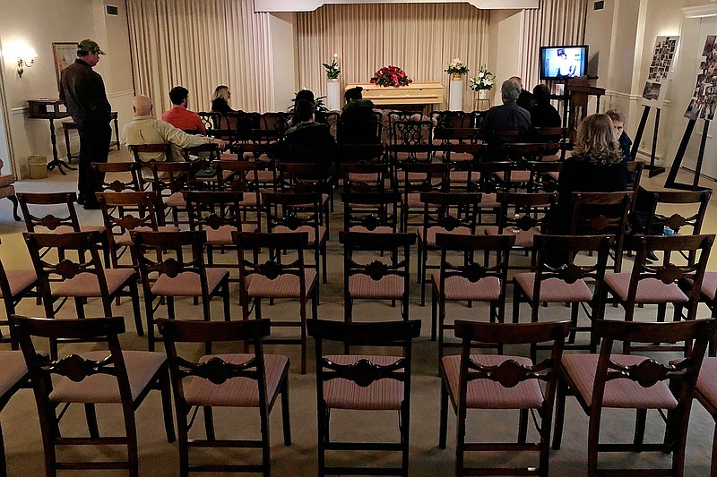 This March 18, 2020 file photo shows a funeral that was affected by new rules put in place due to the coronavirus outbreak in Milwaukee. Wisconsin Gov. Tony Evers restricted gatherings to less than 10 people the day before. As the COVID-19 death toll mounts, faith leaders are grappling with a heart-wrenching question: How do you conduct a funeral in the midst of a global pandemic? (AP Photo/Carrie Antlfinger)