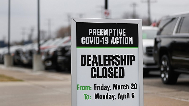 A sign showing an auto dealership closed as a preemptive COVID-19 action is shown Thursday, March 26, 2020 jn Detroit. Automakers' moves to reopen plants in the U.S. come as new auto sales are expected to fall dramatically for the month of March. Edmunds.com expects March sales to fall nearly 36% from a year earlier. (AP Photo/Paul Sancya)