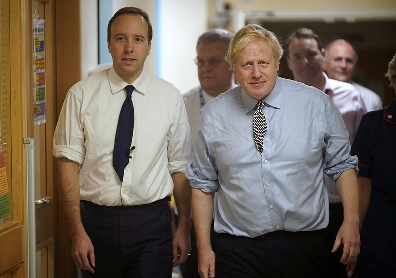 FILE - In this Friday, Nov. 22, 2019 file photo, Britain's  Prime Minister Boris Johnson, right, and Health Minister Matt Hancock visit Bassetlaw District General Hospital on their General Election campaign in Worksop, England. Matt Hancock has tested positive for the new coronavirus, Friday March 27, 2020, the same day as Prime Minister Boris Johnson was confirmed to have COVID-19. (Christopher Furlong/Pool via AP, File)