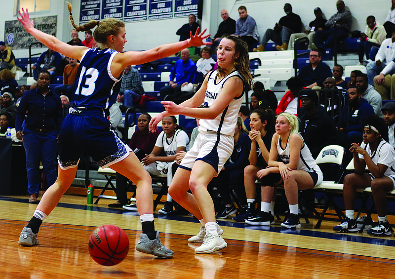 Lincoln guard Natasha Elliott passes the ball around Washburn guard Taylor Johnson during a game this past season at Jason Gym. Elliott is one of nine underclassmen who could return to the Blue Tigers next season.