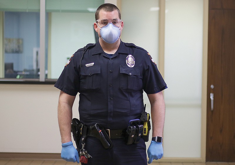 Jefferson City Police officer Adam Lueckenhoff demonstrates the gear the police officers will wear to protect themselves from the spread of coronavirus. The gear includes eye protection, a face mask and a pair of gloves.