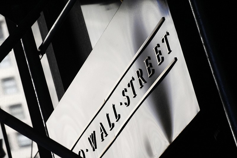 FILE - This July 15, 2013, file photo, shows a sign for Wall Street outside the New York Stock Exchange.  Global stock markets are sharply lower on deepening worries over damage from the coronavirus pandemic. Benchmarks fell in Paris, London and Frankfurt on Wednesday, April 1, 2020.  (AP Photo/Mark Lennihan, File)