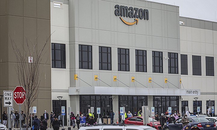 In this March 30, 2020 file photo, workers at Amazon's fulfillment center in Staten Island, N.Y., gather outside to protest work conditions in the company's warehouse in New York. Amazon fired a worker who staged the walkout to demand greater protection against the new coronavirus, saying the employee himself flaunted distancing rules and put others at risk.  The decision prompted a rebuke from New York Attorney General Letitia James, who called on the National Labor Relations Board to investigate. (AP Photo/Bebeto Matthews, File )