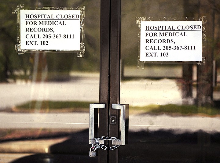 In this March 26, 2020, photo, closed signs hang on a recently closed Pickens County Medical Center in Carrollton, Ala. The hospital is one of the latest health care facilities to fall victim to a wave of rural hospital shutdowns across the United States in recent years. With hundreds of other hospitals endangered, residents are worried about getting health care amid the coronavirus outbreak, and administrators are trying to keep other facilities afloat. (AP Photo/Jay Reeves)