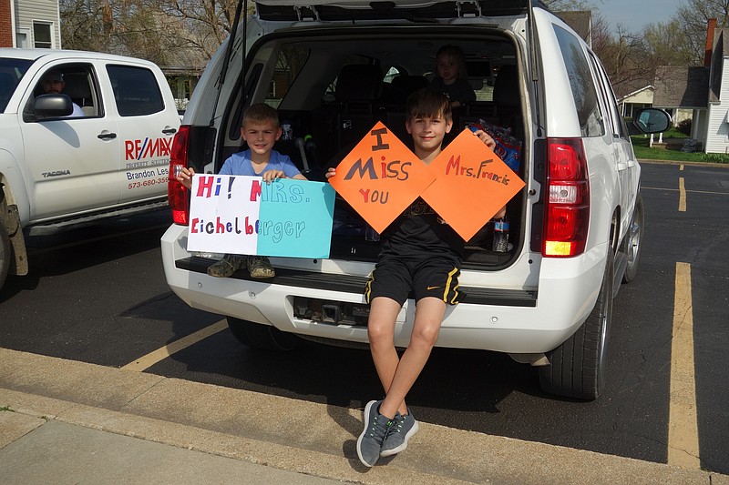 <p>Democrat photo/Paula Tredway</p><p>Second-grader Noah Less and fourth-grader Kolby Less were watching the parade on Oak Street with signs in hand waiting to see their teachers, Mrs. Francis and Mrs. Eichelberger.</p>