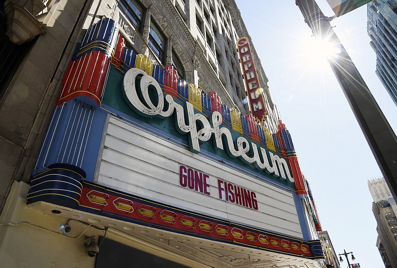 FILE - In this March 25, 2020 file photo, a "Gone Fishing" message is posted on the closed Orpheum Theatre's marquee in Los Angeles. Movie theaters may be closed, but friends are still finding ways to watch together while staying apart thanks to applications like Netflix Party. Movie studios are getting in on the action too, with “watch parties” for old favorites like “Legally Blonde” and new releases like “Emma” on Facebook and Twitter. (AP Photo/Chris Pizzello, File)