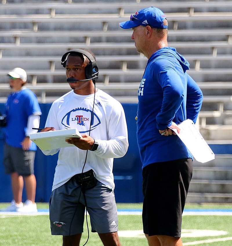 Eric Sutton, a student assistant at Louisiana Tech, converses with Bulldog head coach Skip Holtz during a team practice. Sutton was the equipment manager for two seasons at La. Tech before he was promoted to student assistant with the running backs. (Submitted photo)
