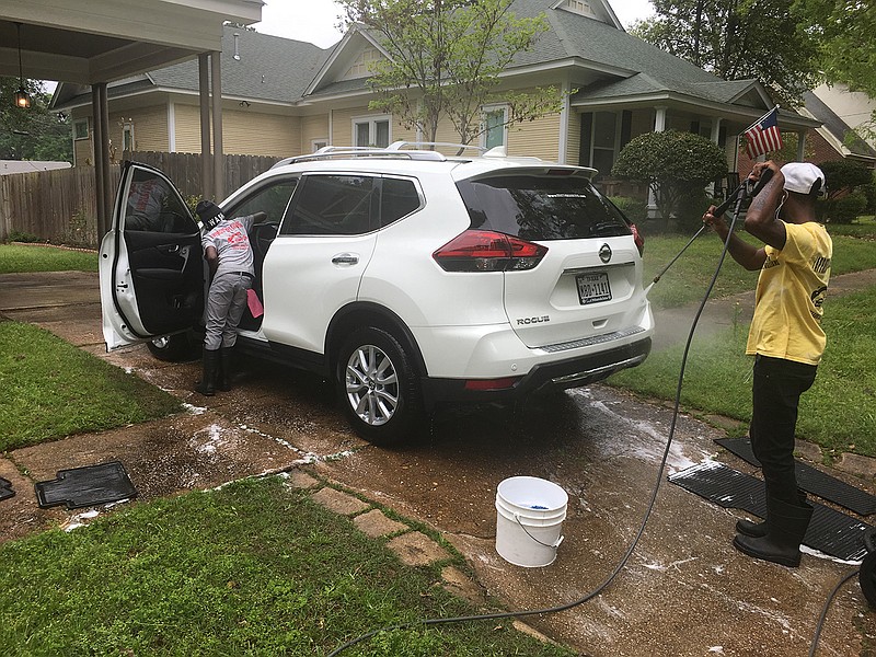 Richard Williams cleans the inside while his father, Cortez Williams, washes the exterior of a car. This was the first of about seven appointments the Williamses would complete on this sunny day.
